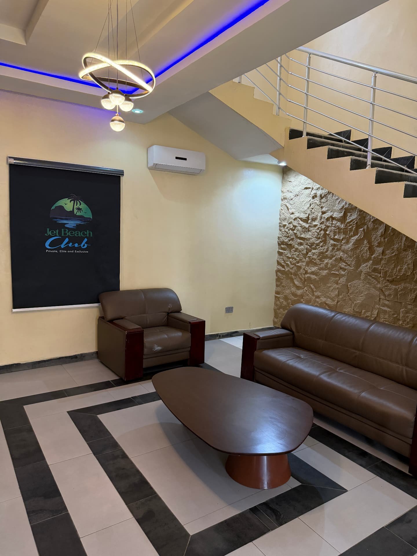 Reception lounge with Jet Beach Club branding, leather sofas and chandelier in the 2 Bed pool apartment